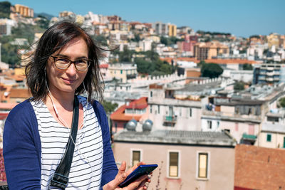 Happy smiling woman listening music, song or audio guide at mobile phone