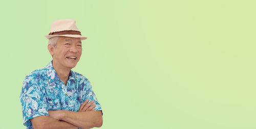 Portrait of smiling man standing against gray background