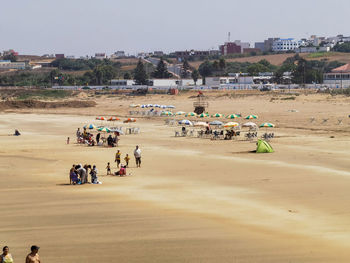 Aerial view over a moroccan beach with many people enjoying their summer holidays