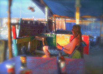 Woman sitting on amusement park ride at night