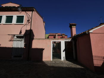 Low angle view of buildings against clear blue sky of burano close  venice, italy.