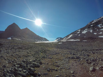 Scenic view of snowcapped mountains against sky on sunny day