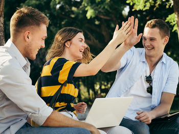 Smiling friends studying together at university campus