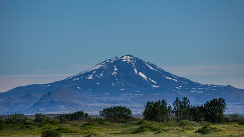 Scenic view of snowcapped mountain against blue sky