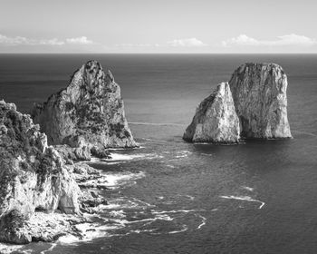 Rock formations by sea against sky