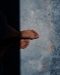 Low section of man standing on concrete wall