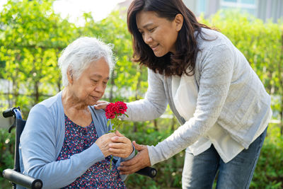 Side view of young woman holding flowers