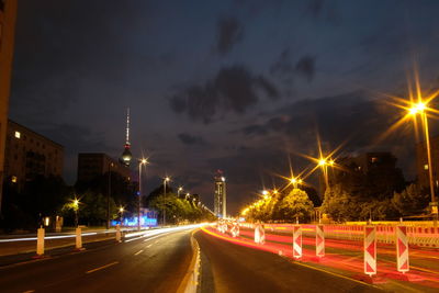 Light trails on road against sky at night