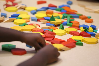 Close-up cropped girl playing with toy blocks on table