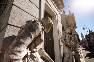 Low angle view of statue against buildings in city