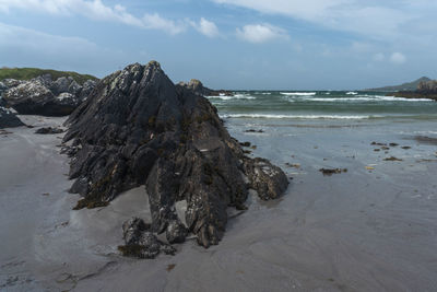 Scenic view of rocks on beach against sky