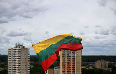 Flag against buildings in city against sky