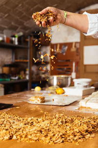 Cropped hand of person preparing food on table