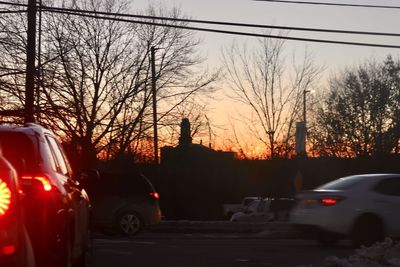 Cars parked on street at sunset