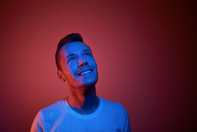 Young man standing against blue background