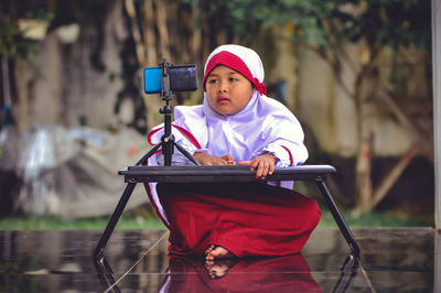 Full length of boy sitting in water