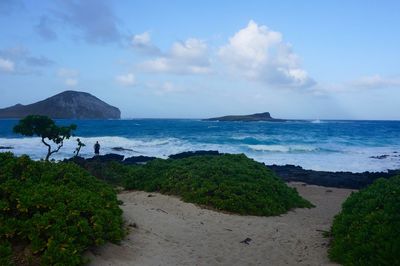 Scenic view of beach against sky with high waves 