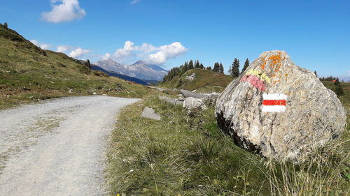 Road by mountains against sky