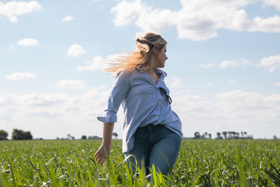 Portrait of young woman standing on field