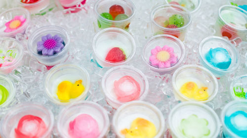 High angle view of decorated drinks amidst ice cubes at table