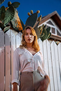 Portrait of woman standing against built structure