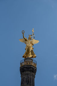 Low angle view of statue of liberty against blue sky