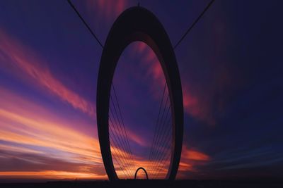 Low angle view of silhouette ferris wheel against sky during sunset
