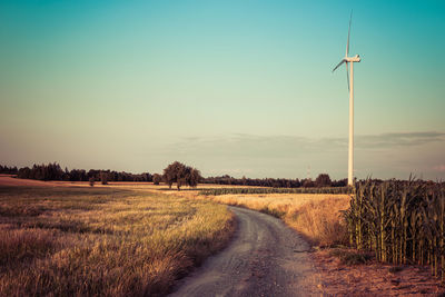 Road amidst field against sky