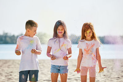 Portrait of smiling friends standing at beach