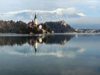 Scenic view of lake by buildings against sky