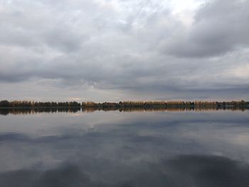 Scenic view of calm lake against cloudy sky