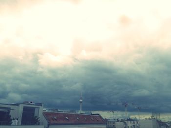 Aerial view of city against cloudy sky