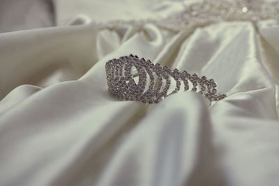 Close-up of jewelry on white textile