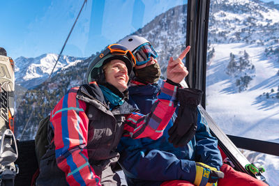 Smiling man with umbrella on snowcapped mountain