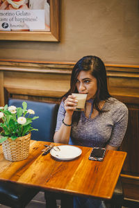 Young woman sitting at restaurant table