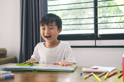 Boy sitting on table at home