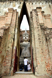 Rear view of female sculpture outside historic building