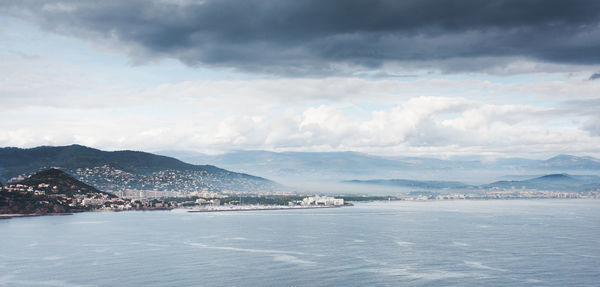 Scenic view of sea and mountains against sky