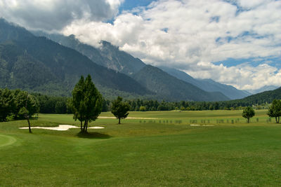 Scenic view of golf course against sky