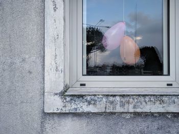 Reflection of building on window and balloons hanging after a party