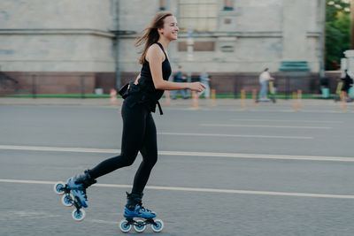 Full length of man skateboarding on street in city