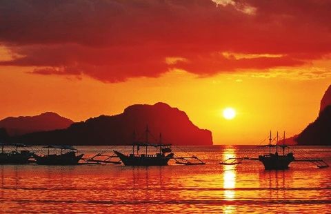 SILHOUETTE BOATS IN SEA AGAINST DRAMATIC SKY