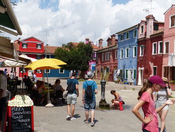 People walking on street against buildings in city