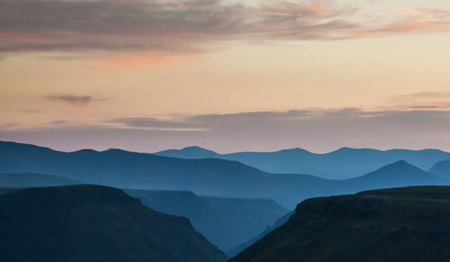 Scenic view of silhouette mountains against sky at sunset