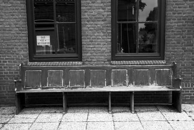 Empty bench against building