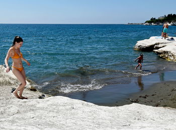 Woman on beach against clear sky