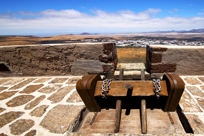 Deck chairs on mountain against sky