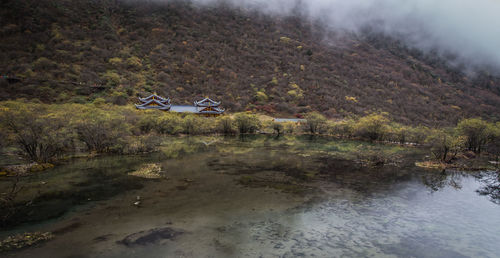 Scenic view of lake by mountain against trees