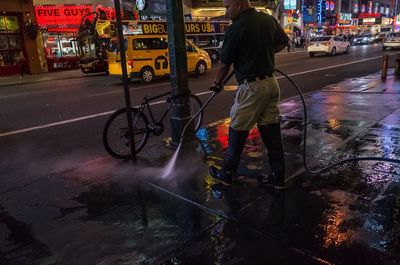 Man riding bicycle on wet street in rainy season