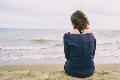 Rear view of woman looking at sea against sky